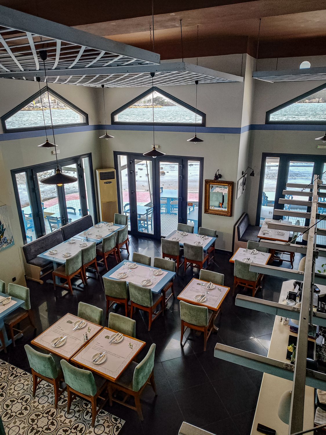 The dining room seen from the upper level, with triangular windows looking out over the bay